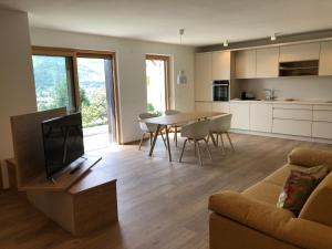 a living room with a couch and a table with a television at Apartment42 in Bressanone