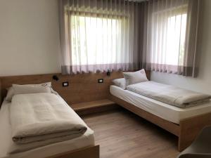 1 Schlafzimmer mit 2 Betten und einem Fenster in der Unterkunft Apartment42 in Brixen