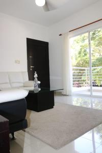 a white living room with a couch and a table at Apartamento Amueblado Amplio Tranquilo Privado Como tu lo Mereces in Santiago de los Caballeros