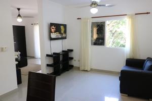 a living room with a blue couch and a window at Apartamento Amueblado Amplio Tranquilo Privado Como tu lo Mereces in Santiago de los Caballeros