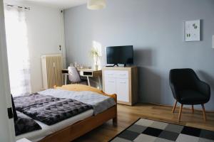 a bedroom with a bed and a desk with a television at Levendula Apartman Pécs in Pécs