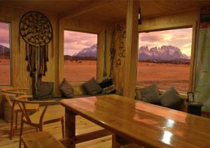 sala de estar con mesa y vistas a las montañas en Vista al Paine - Refugio de Aventura, en Torres del Paine