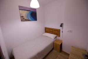 a small bedroom with a bed and a painting on the wall at Casa Manzana in Morella