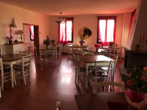 a dining room with tables and chairs and red curtains at Tenuta I Ginepri in Ozzano dell'Emilia