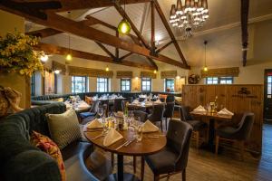 ein Restaurant mit Sofas, Tischen und Stühlen in der Unterkunft The Royal Arms Hotel in Sutton Cheney