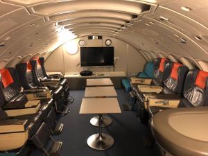 une chambre avec des chaises et une télévision dans un avion dans l'établissement STF Jumbo Stay Stockholm, à Arlanda