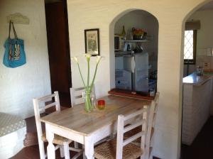 a dining room table with a vase of flowers on it at Coco Loco Lodge in La Paloma