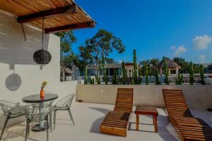 a patio with a table and chairs and a table and chairs at Alma De Flores Private Pools Suites in Tulum