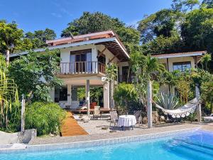 a house with a hammock and a swimming pool at Casa de la Luna - Private Suites in Santa Teresa Beach