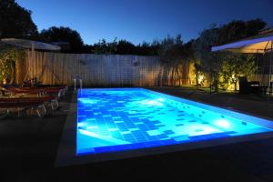 ein nachts beleuchteter Pool in der Unterkunft The Blue Leaf Family Villa in Gennadi