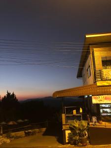 a building with a view of the mountains at night at ดอยตุงเฮงธนาโฮมสเตย์ in Ban I-Ko Pa Kluai