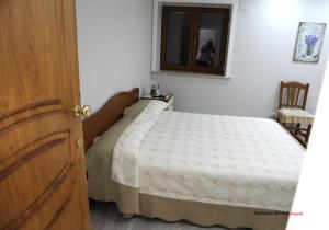 1 dormitorio con 1 cama en una habitación con ventana en VILLA IZZO B&B, en Bagnoli