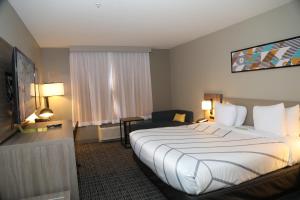 a hotel room with a large bed and a chair at La Quinta by Wyndham Montgomery in Montgomery