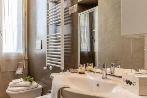 La salle de bains est pourvue d'un lavabo, de toilettes et d'un miroir. dans l'établissement La Casa Rosa, à Terni