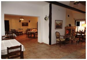 a living room with tables and chairs and a fireplace at Alėjos Ąžuolas in Leipalingis