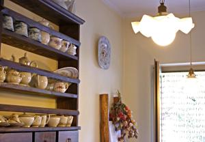 a kitchen with a shelf full of pottery at Silenzio e Buio in Calizzano