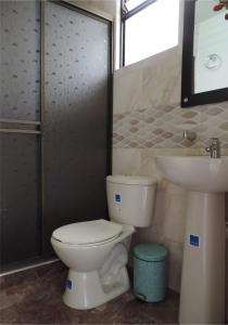 a bathroom with a toilet and a sink at Sueños Vividos Hospedaje in Sogamoso
