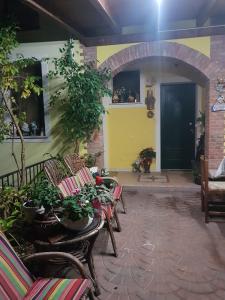 un patio con sillas y plantas y una puerta negra en B&B Kristina en Quinto Vicentino