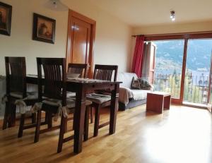 a living room with a table and chairs and a couch at APARTAMENT CA DE GALLISCA B 4PAX in Pla de l'Ermita
