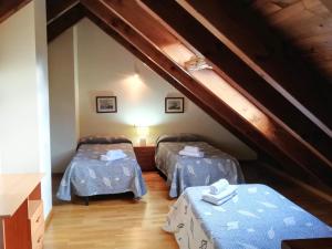 a attic room with two beds with blue sheets at Apartament Ca de Gallisca in Pla de l'Ermita