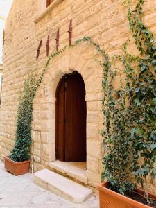 a brick building with a wooden door and ivy at B&B MARNUDD in Bisceglie