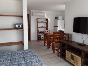 1 dormitorio con 1 cama y comedor con mesa en Deja Vu, en Punta del Diablo