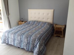 1 dormitorio con 1 cama con edredón azul y blanco en Deja Vu, en Punta del Diablo
