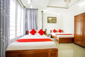 um quarto com 2 camas e almofadas vermelhas em Legend Connect Homestay em Hoi An
