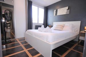 Cama blanca en habitación con ventana en Le Grand Large - Apartment parking & balcony by the lake modern bright en Annecy