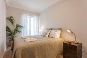 een slaapkamer met een bed met twee handdoeken erop bij FLH Campo de Ourique Bright Apartment in Lissabon