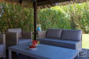un patio con sofá y mesa con un bol de fruta en Villa Isla by Abahana Villas, en Benissa