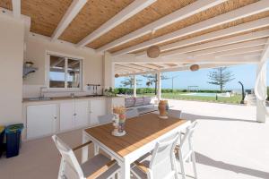 Una cocina y un comedor con mesa y sillas de madera. en Sea Home - IsulaTravel, en Marina di Modica