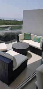 two wicker chairs and couches on a balcony at Apartamento Morros Epic Cartagena in Cartagena de Indias