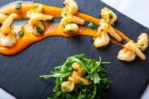 a plate of food with shrimp and greens on it at The Wensleydale Hotel in Middleham