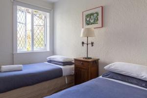 een slaapkamer met 2 bedden en een raam en een lamp bij Highbury Apartments in Launceston
