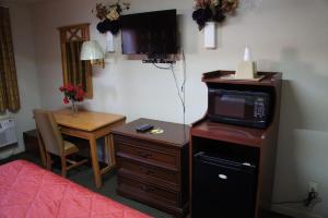 バーリントンにあるRoyalinn & suitesの電子レンジと小さなテーブルが備わるホテルルームです。