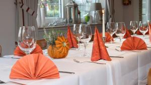 a table with orange napkins and wine glasses on it at Gasthof&Hotel Schmitz in Papenburg