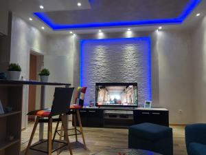 a living room with a fireplace with blue lighting at Apartmani Venera in Belgrade