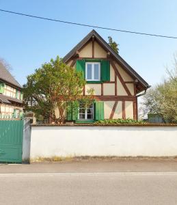 een klein huis met een groen raam aan een muur bij Gîte indépendant - Bretzel et Bergamote in Richtolsheim