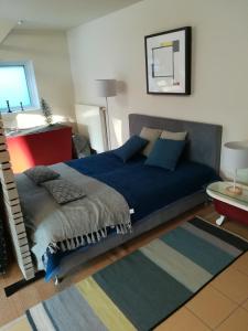 a bedroom with a blue bed and a rug at GOLF APARTMENT in Schilde