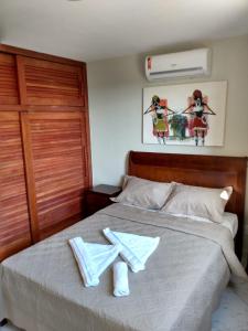ein Schlafzimmer mit einem Bett mit zwei Handtüchern darauf in der Unterkunft Flat Pipa Brisas do Amor in Pipa