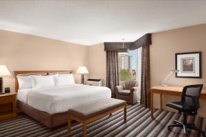 a hotel room with a bed and a desk at Royal Hotel West Edmonton, Trademark Collection by Wyndham in Edmonton +102 photos