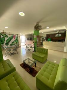 uma sala de estar com sofás verdes e uma mesa em Hotel Plataneras Confort em Turbo