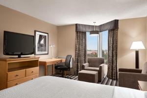 a hotel room with a bed and a desk and a television at Royal Hotel West Edmonton, Trademark Collection by Wyndham in Edmonton