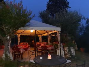 Tienda de campaña con mesas y sillas en un jardín por la noche en Agriturismo Borgo La Casetta, en San Baronto
