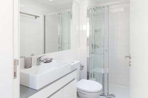 ein weißes Bad mit einem Waschbecken und einer Dusche in der Unterkunft Porto Center Apartments in Porto