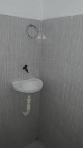 baño con lavabo y un pájaro en la pared en Pousada Progresso en Parnaíba