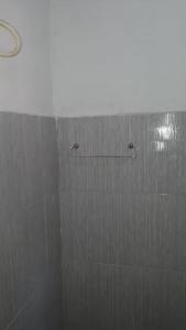 a shower with two hooks on the wall at Pousada Progresso in Parnaíba