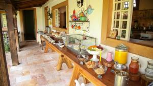 a kitchen with a long table with food on it at Pousada das Cavalhadas in Pirenópolis