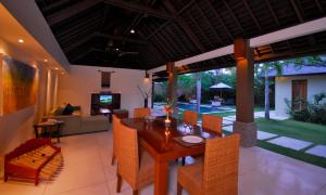 a dining room and living room with a table and chairs at Nomad Hub Canggu Bali in Canggu